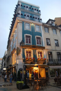 European-style building with ornate balconies and warm lighting, photographed at Casa Portuguesa do Pastel de Bacalhau in Lisbon, Portugal.